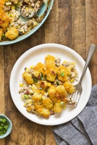 Delicious ground veal, flavorful bacon, corn, cheddar cheese, sour cream, and crispy tater tots make this Cowboy Casserole a family favorite!
